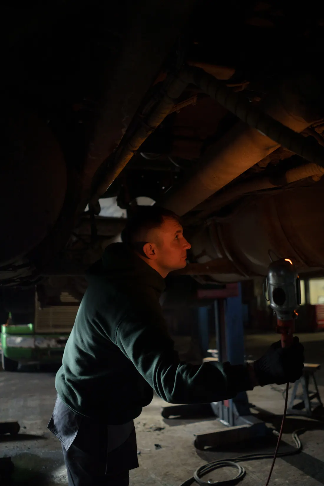 Illustrative stock photograph of a mechanic inspecting a raised vehicle